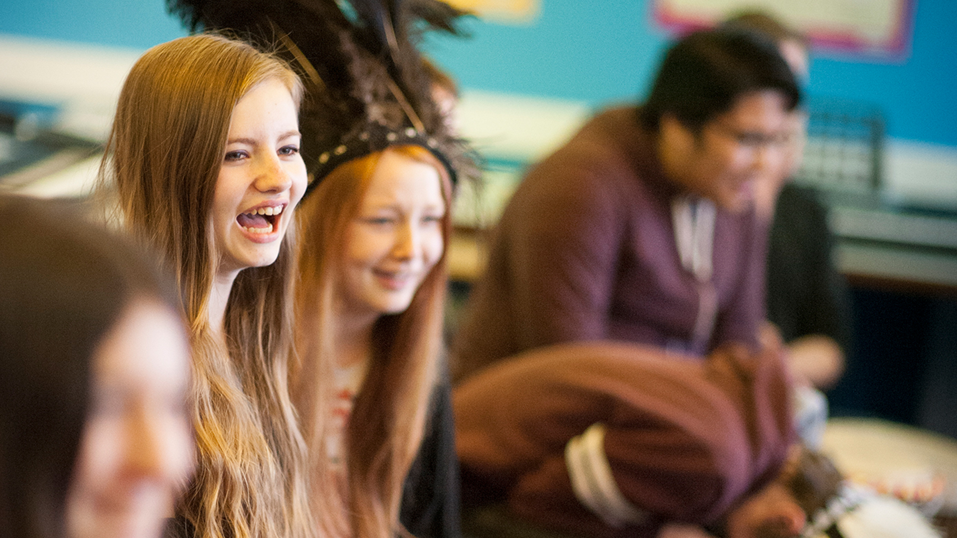 Group of young people looking to the side and laughing as part of an activity with cae.