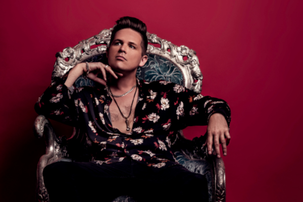 A man in a floral shirt sat in large throne like chair